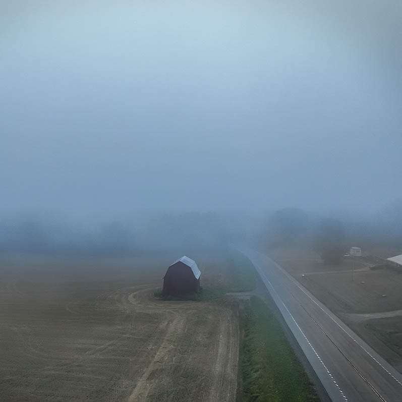 Drone photograph of a beautiful old barn in the fog